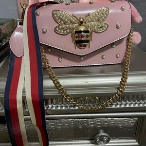 Pink shoulder bag with bee accents